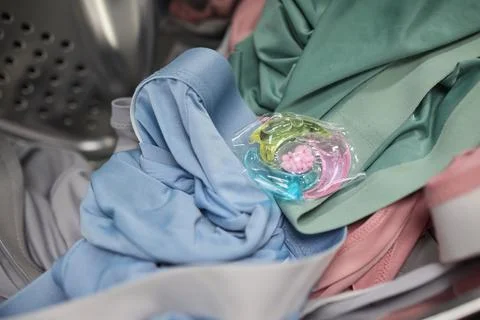 Using Laundry Detergent Pods While Doing Laundry in the Washing Machine with Stock Photos