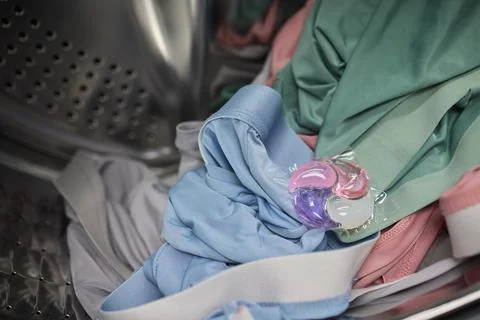 Using Laundry Detergent Pods While Doing Laundry in the Washing Machine with Stock Photos