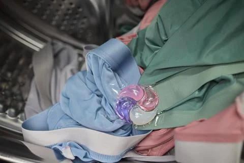 Using Laundry Detergent Pods While Doing Laundry in the Washing Machine with Stock Photos