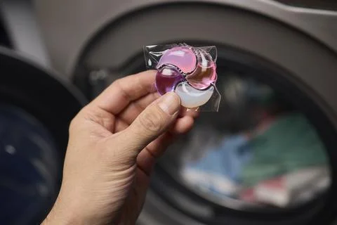 Using Laundry Detergent Pods While Doing Laundry in the Washing Machine with Stock Photos