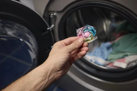 Using Laundry Detergent Pods While Doing Laundry in the Washing Machine with Stock Photos