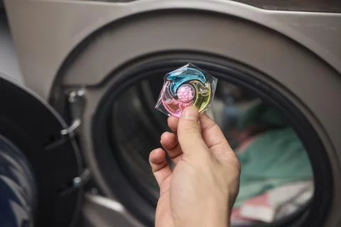 Using Laundry Detergent Pods While Doing Laundry in the Washing Machine with Stock Photos