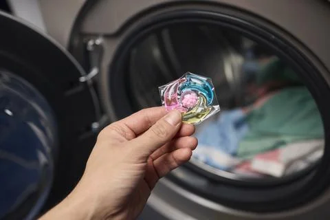 Using Laundry Detergent Pods While Doing Laundry in the Washing Machine with Stock Photos