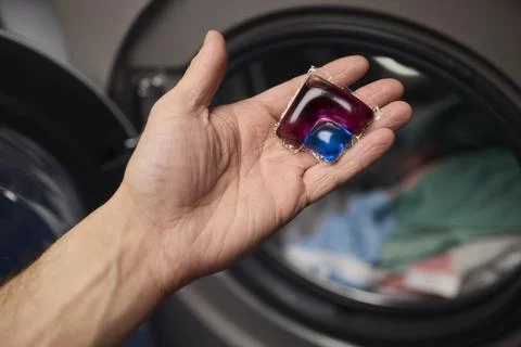 Using Laundry Detergent Pods While Doing Laundry in the Washing Machine with Stock Photos