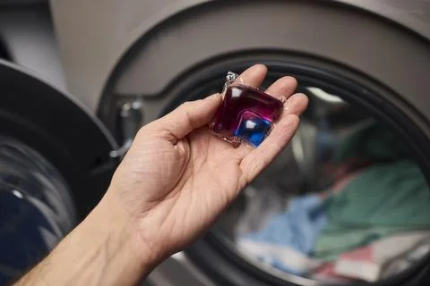Using Laundry Detergent Pods While Doing Laundry in the Washing Machine with Stock Photos