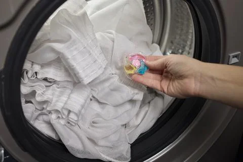 Using Laundry Detergent Pods While Doing Laundry in the Washing Machine with Stock Photos