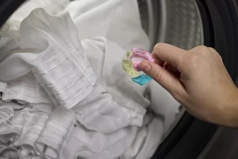 Using Laundry Detergent Pods While Doing Laundry in the Washing Machine with Stock Photos