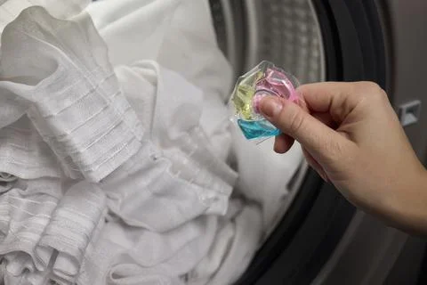 Using Laundry Detergent Pods While Doing Laundry in the Washing Machine with Stock Photos