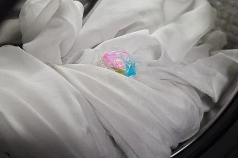 Using Laundry Detergent Pods While Doing Laundry in the Washing Machine with Stock Photos
