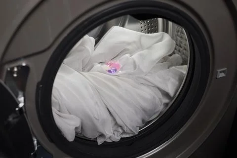 Using Laundry Detergent Pods While Doing Laundry in the Washing Machine with Stock Photos