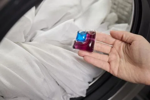 Using Laundry Detergent Pods While Doing Laundry in the Washing Machine with Stock Photos