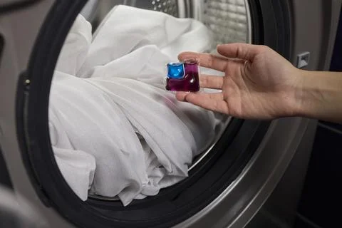 Using Laundry Detergent Pods While Doing Laundry in the Washing Machine with Stock Photos