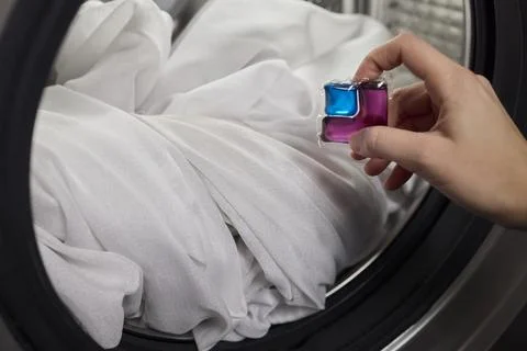 Using Laundry Detergent Pods While Doing Laundry in the Washing Machine with Stock Photos