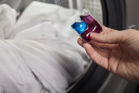 Using Laundry Detergent Pods While Doing Laundry in the Washing Machine with Stock Photos
