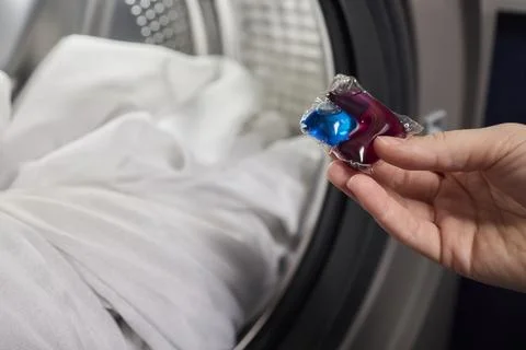 Using Laundry Detergent Pods While Doing Laundry in the Washing Machine with Stock Photos