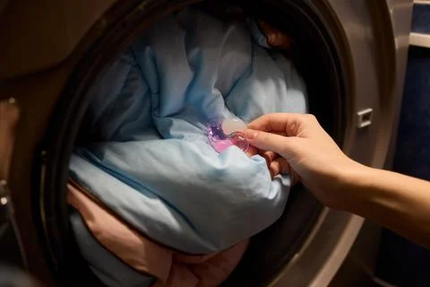 Using Laundry Detergent Pods While Doing Laundry in the Washing Machine with Stock Photos