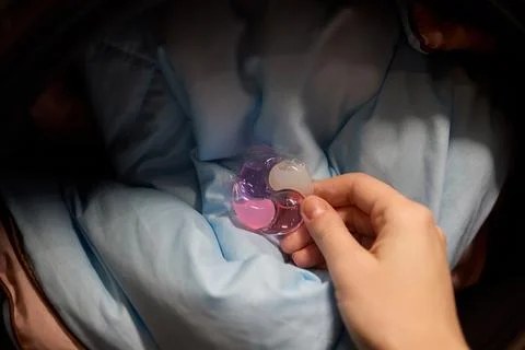 Using Laundry Detergent Pods While Doing Laundry in the Washing Machine with Stock Photos