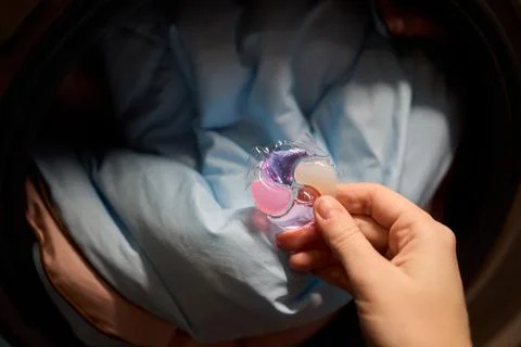Using Laundry Detergent Pods While Doing Laundry in the Washing Machine with Stock Photos