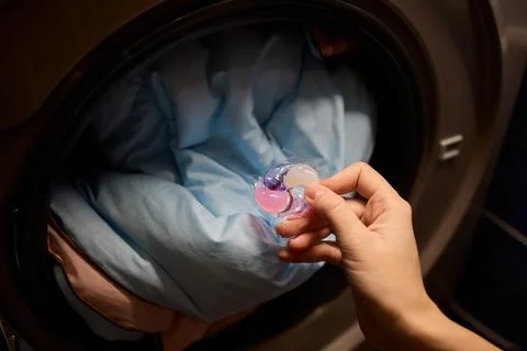 Using Laundry Detergent Pods While Doing Laundry in the Washing Machine with Stock Photos