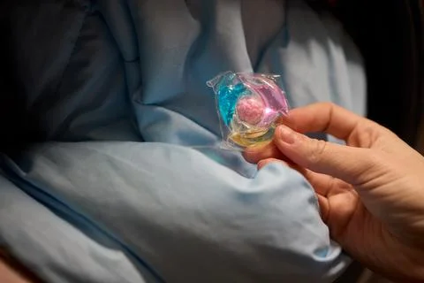 Using Laundry Detergent Pods While Doing Laundry in the Washing Machine with Stock Photos