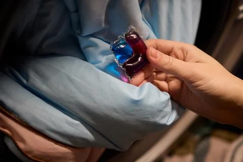 Using Laundry Detergent Pods While Doing Laundry in the Washing Machine with Stock Photos