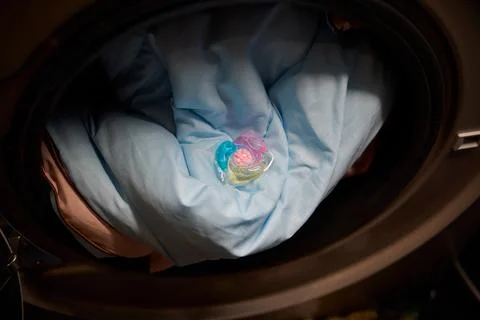 Using Laundry Detergent Pods While Doing Laundry in the Washing Machine with Stock Photos