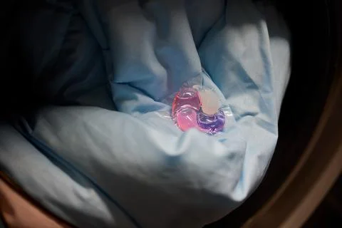 Using Laundry Detergent Pods While Doing Laundry in the Washing Machine with Stock Photos