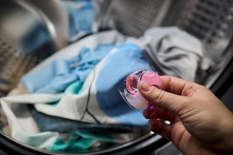 Using Laundry Detergent Pods While Doing Laundry in the Washing Machine with Stock Photos