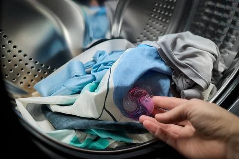 Using Laundry Detergent Pods While Doing Laundry in the Washing Machine with Stock Photos