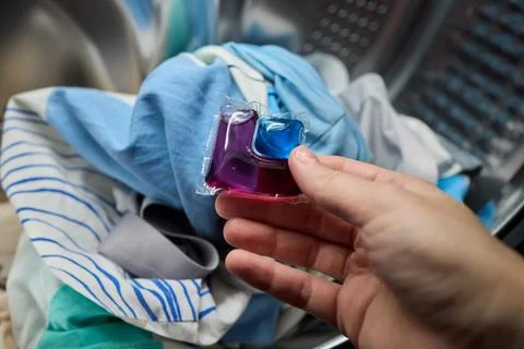 Using Laundry Detergent Pods While Doing Laundry in the Washing Machine with Stock Photos