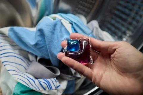 Using Laundry Detergent Pods While Doing Laundry in the Washing Machine with Stock Photos