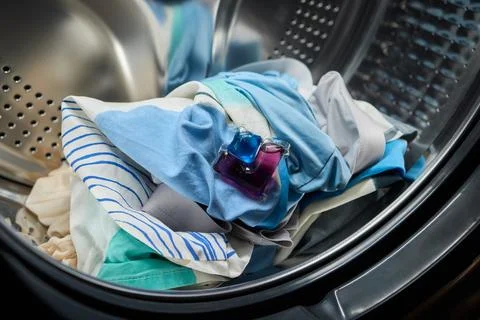 Using Laundry Detergent Pods While Doing Laundry in the Washing Machine with Stock Photos