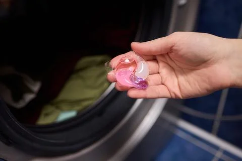 Using Laundry Detergent Pods While Doing Laundry in the Washing Machine with Stock Photos