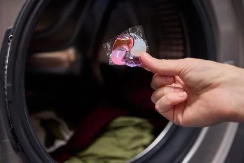 Using Laundry Detergent Pods While Doing Laundry in the Washing Machine with Stock Photos