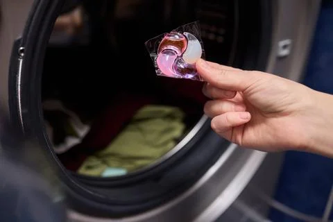 Using Laundry Detergent Pods While Doing Laundry in the Washing Machine with Stock Photos