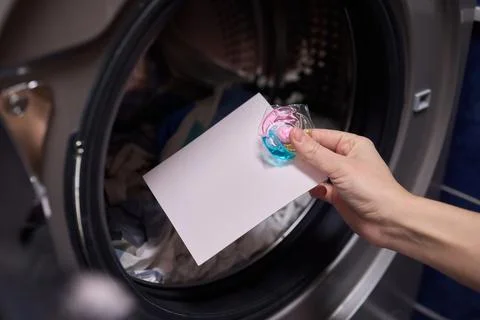 Using Laundry Detergent Pods While Doing Laundry in the Washing Machine with Stock Photos