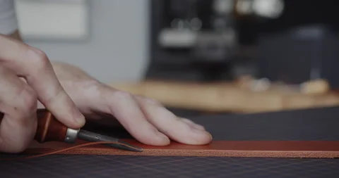 Using leather edge beveler during belt manufacturing process close-up Stock Footage 144892744