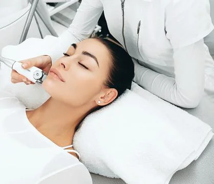 Using the LPG apparatus, the beautician performs a face lift massage. The ski Foto stock