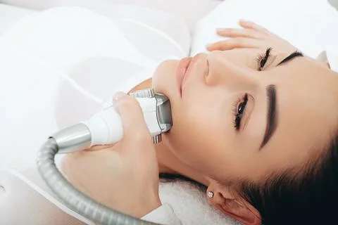Using the LPG apparatus, the beautician performs a face lift massage. Face co Stock Photos