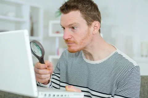 Using a magnifying glass to read something in the internet Stock Photos