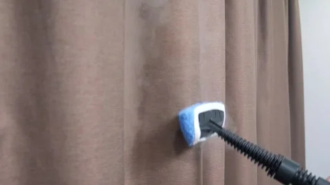 Using a manual steamer for ironing curtains. Stock Footage 297296501
