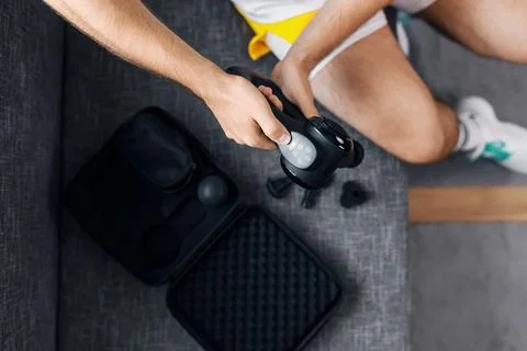 Using a massage gun for percussion therapy and recovery to relieve muscle t.. Stock Photos