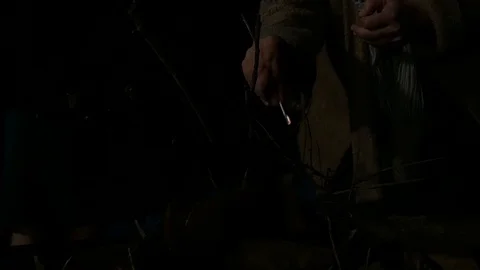 Using match to ignite pile of wood and paper to create campfire Stock Footage 121801713