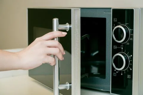 Using microwave oven in the kitchen, close up photo Stock Photos