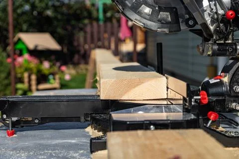 Using a miter saw to cut a piece of wood. Own carpentry workshop. Sawing a wo Stock Photos