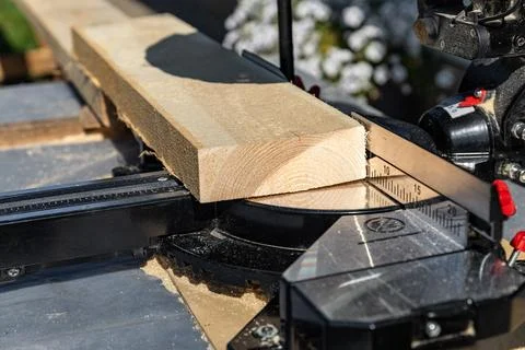 Using a miter saw to cut a piece of wood. Own carpentry workshop. Sawing a wo Stock Photos
