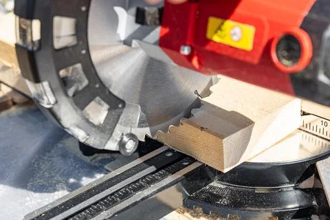 Using a miter saw to cut a piece of wood. Own carpentry workshop. Sawing a wo Stock Photos