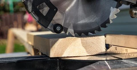 Using a miter saw to cut a piece of wood. Own carpentry workshop. Sawing a wo Stock Photos