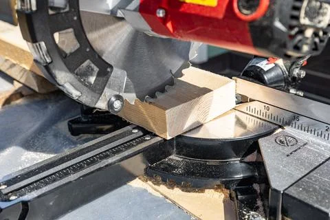 Using a miter saw to cut a piece of wood. Own carpentry workshop. Sawing a wo Stock Photos