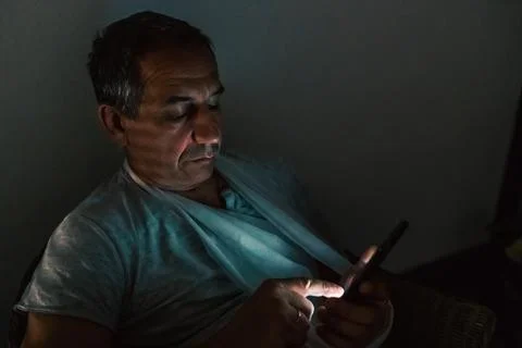 Using mobile apps technology on cell phone late at night Stock Photos